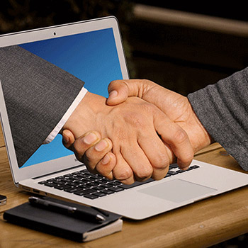hand coming out of computer to shake a hand