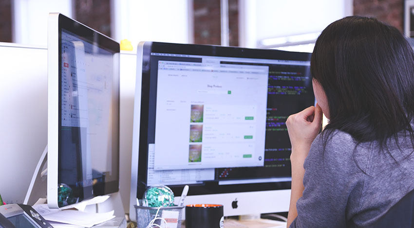 Developer working at desk with multiple monitors