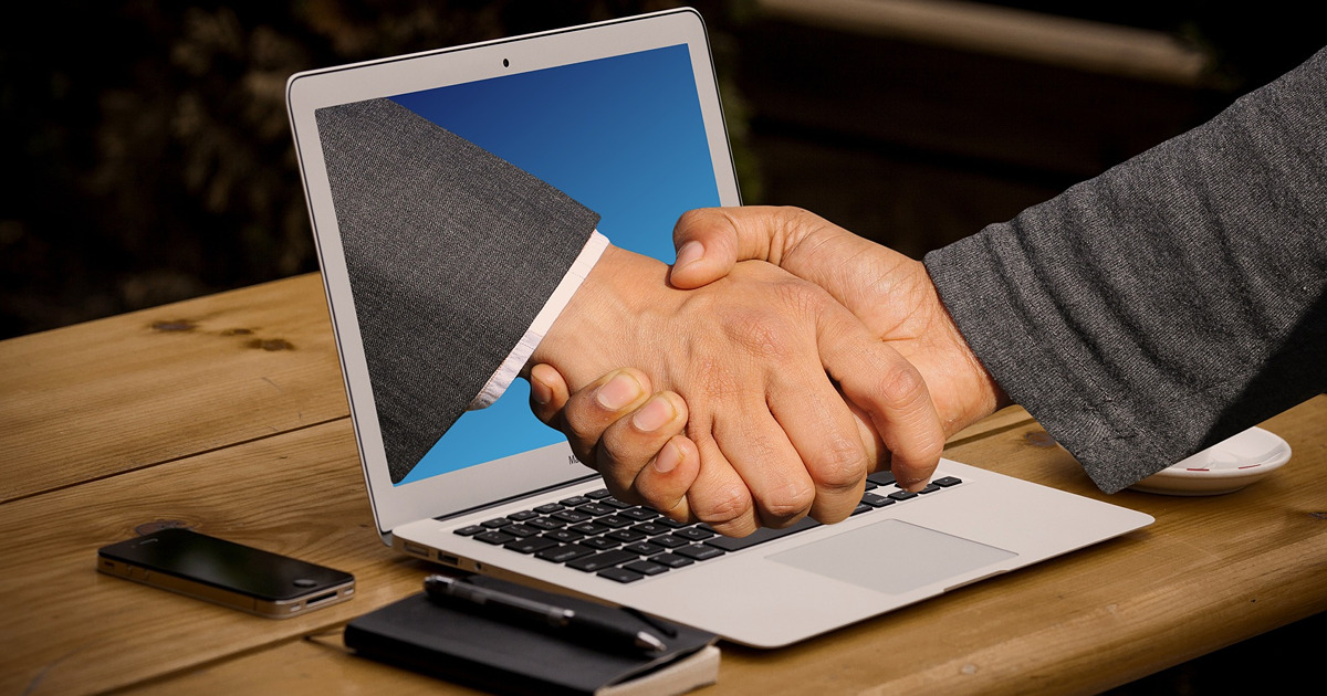 handshake through a laptop screen