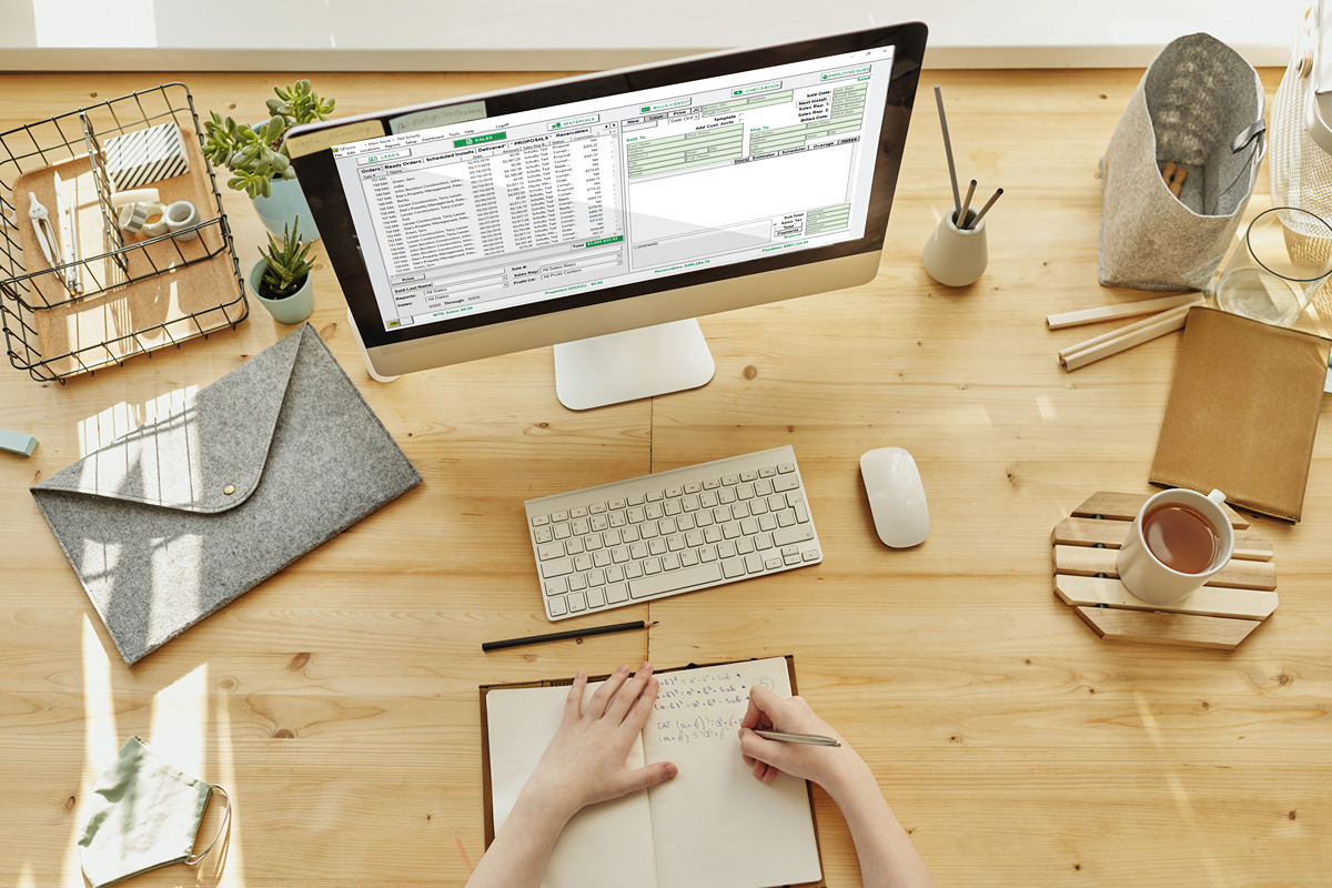 desk with iMac displaying QPro sales screen