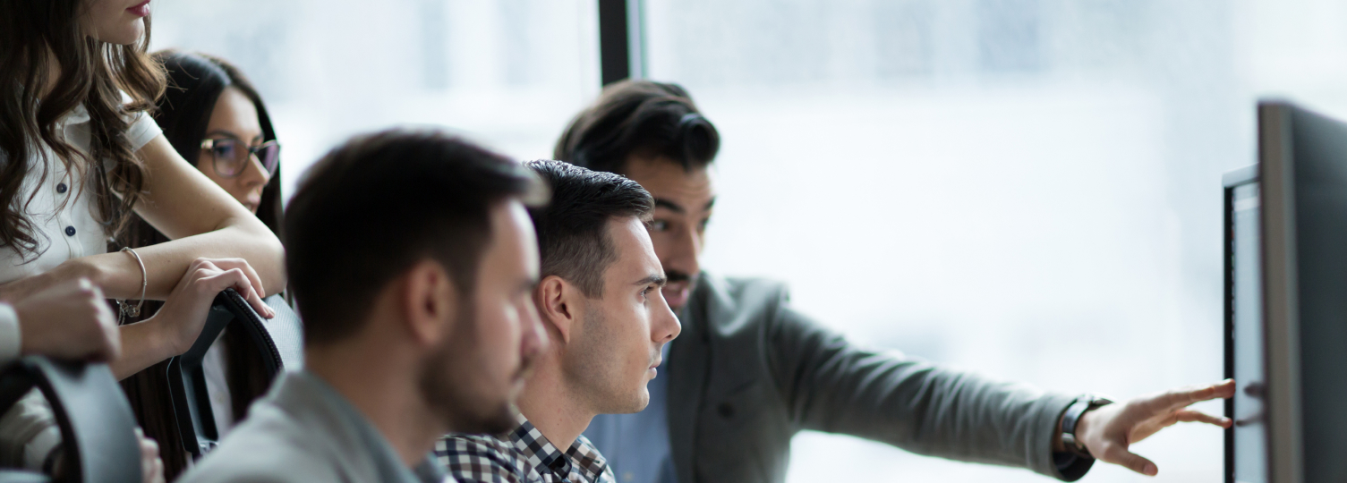 Man refers to computer screen with team